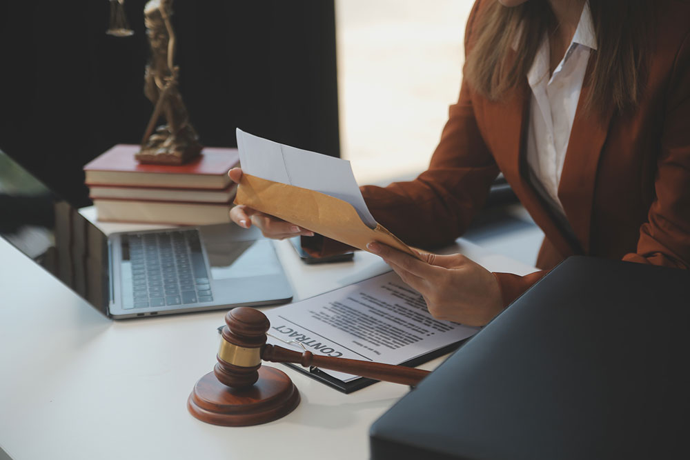 Lawyer working on a laptop with legal documents and law books on a desk