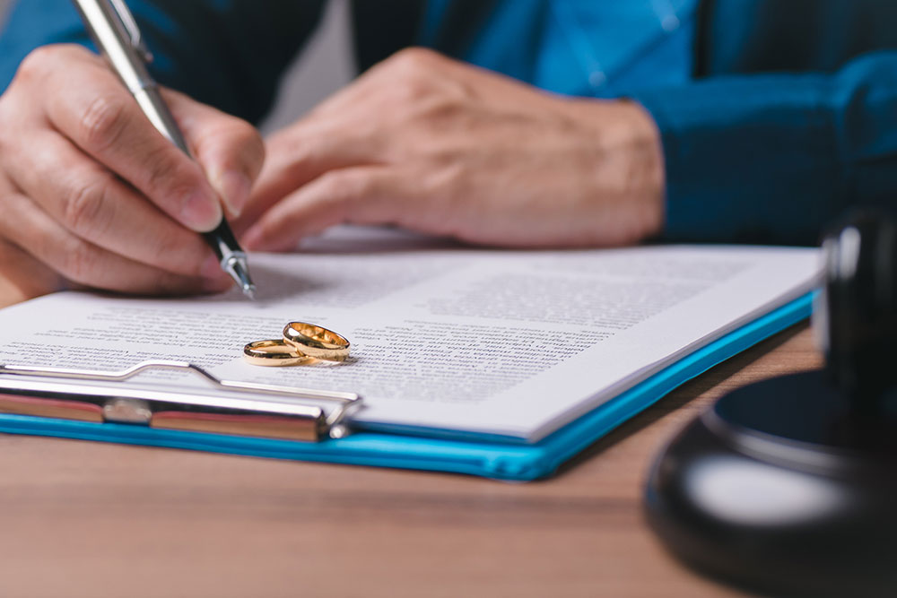 Person writing on paperwork with a pen