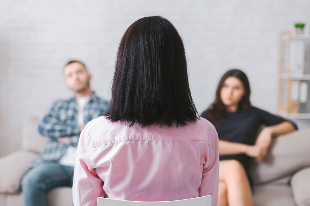 Couple speaking with a neutral professional in a private office setting