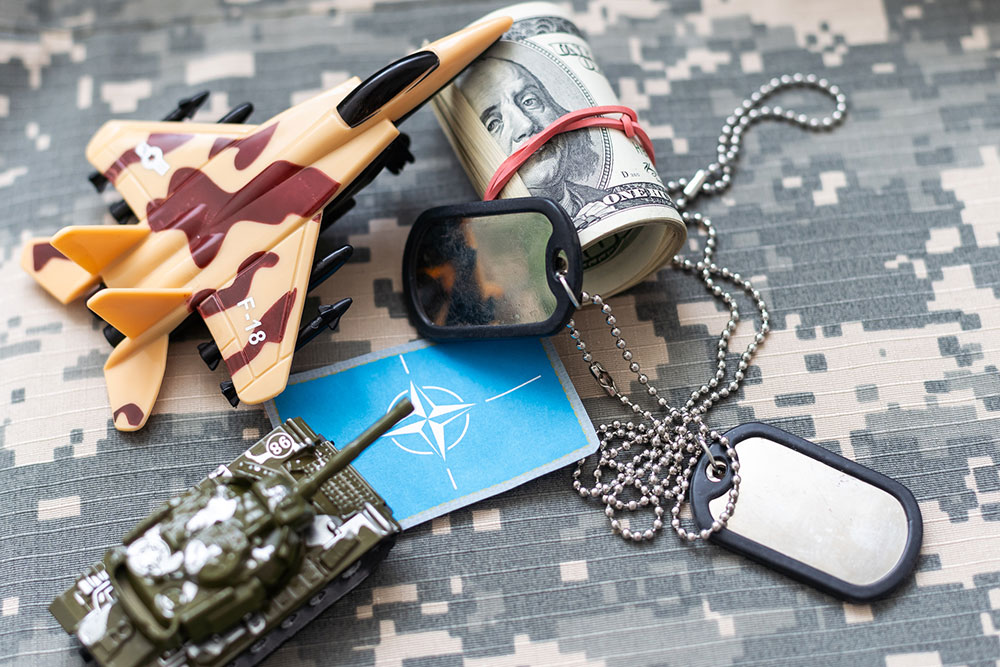 Dog tags resting on a camouflage uniform next to a U.S. flag patch