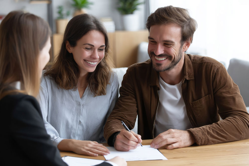 Couple reviewing paperwork with a consultant at a table